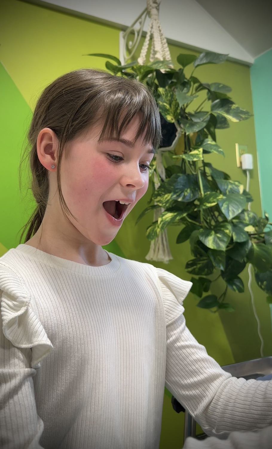 A child beaming with excitement among the studio plants