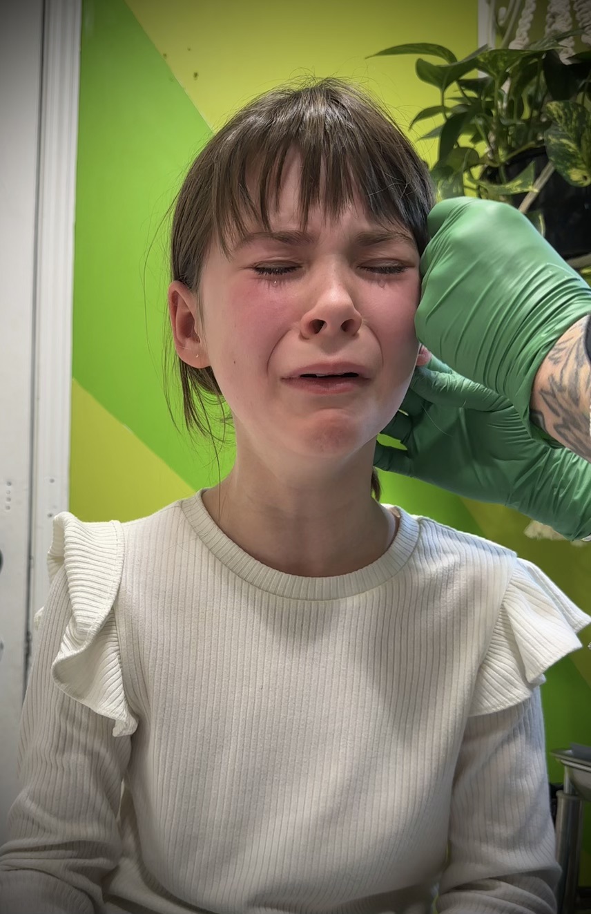 A brave moment during a child's gentle piercing appointment